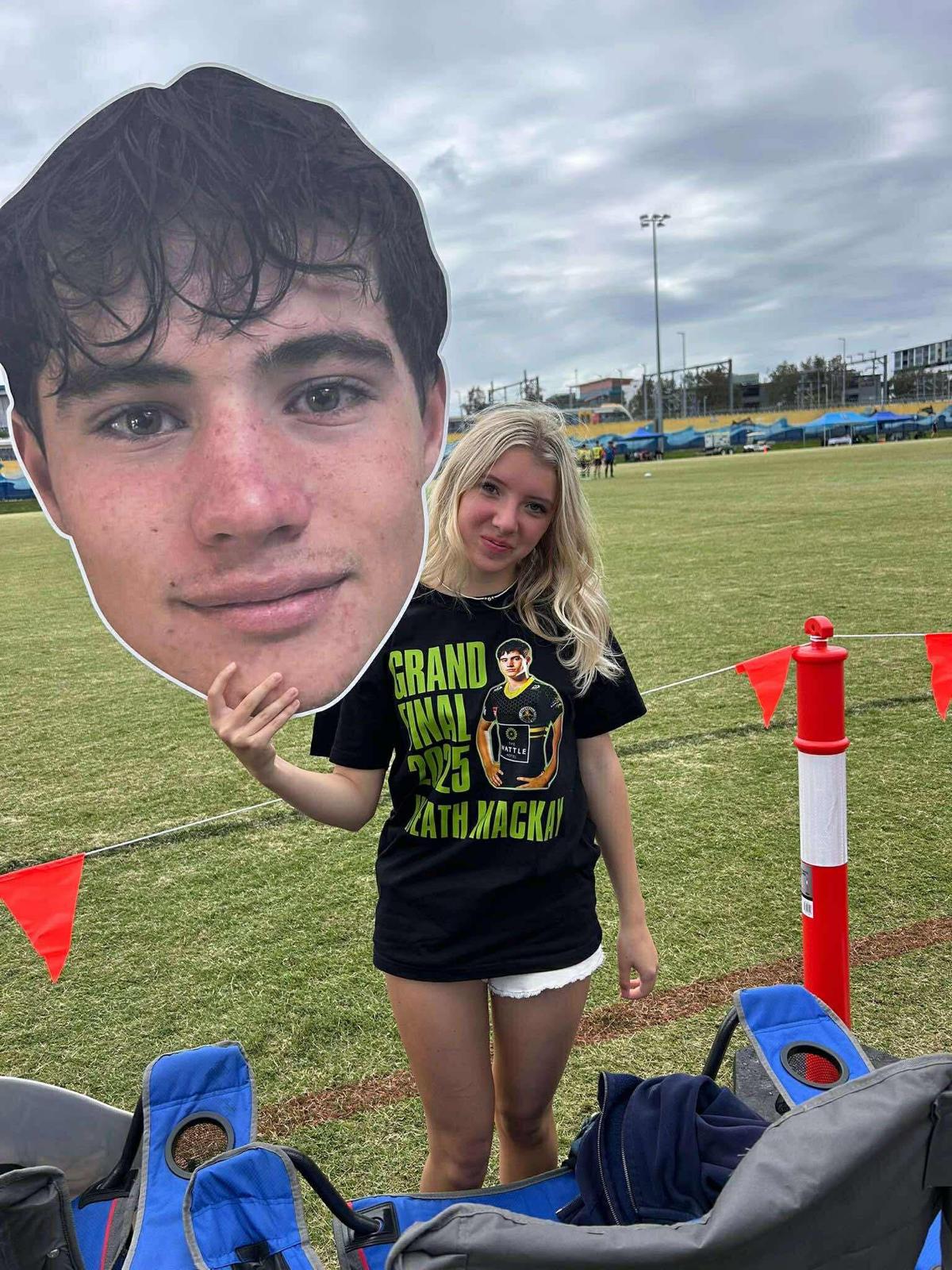 Supporter holding a Big Head on the sideline